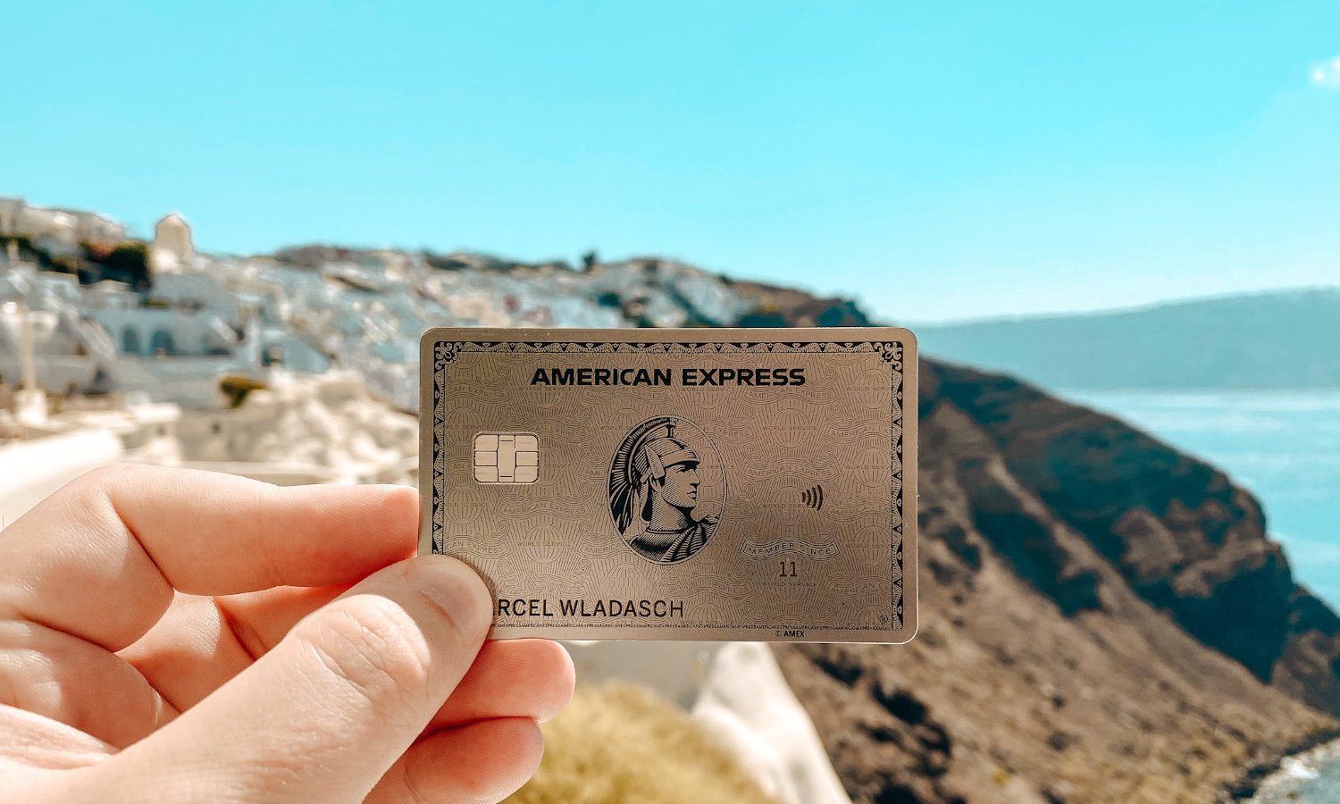 Amex Platinum Card in der Hand vor Bergen und blauem Himmel