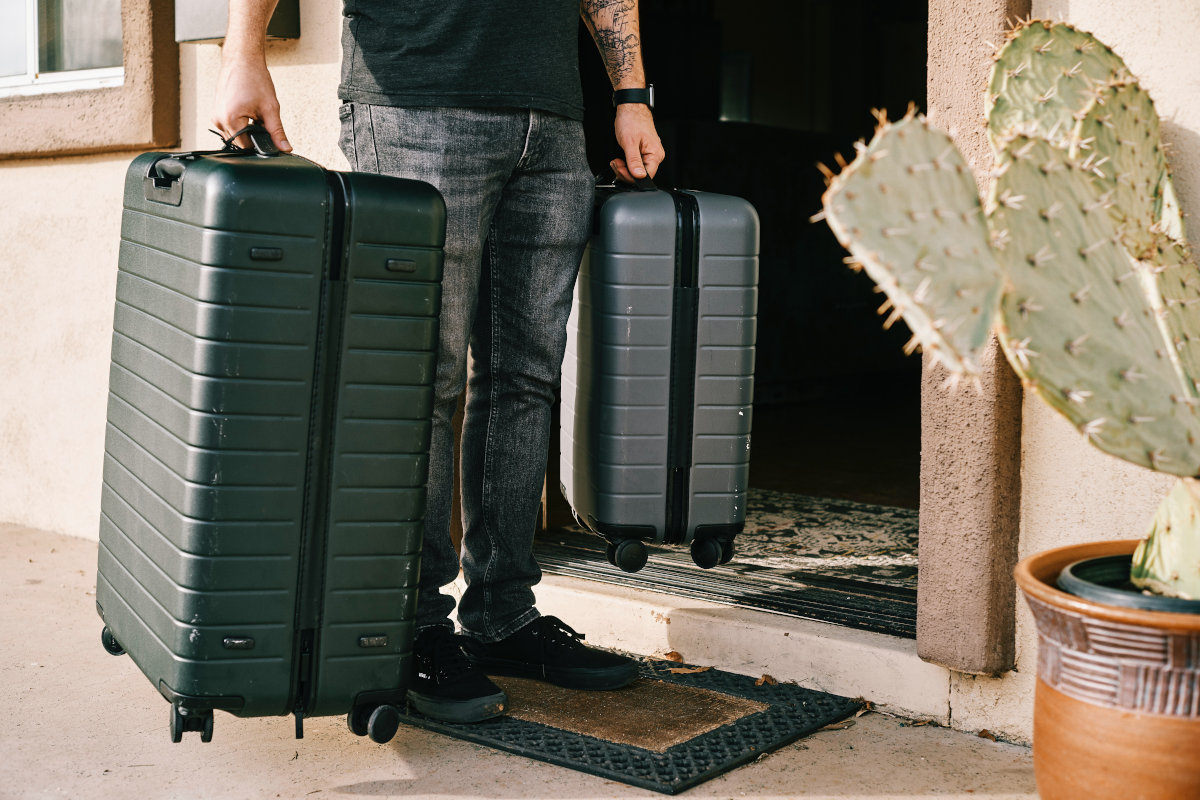 Mann trägt zwei Koffer aus dem Haus