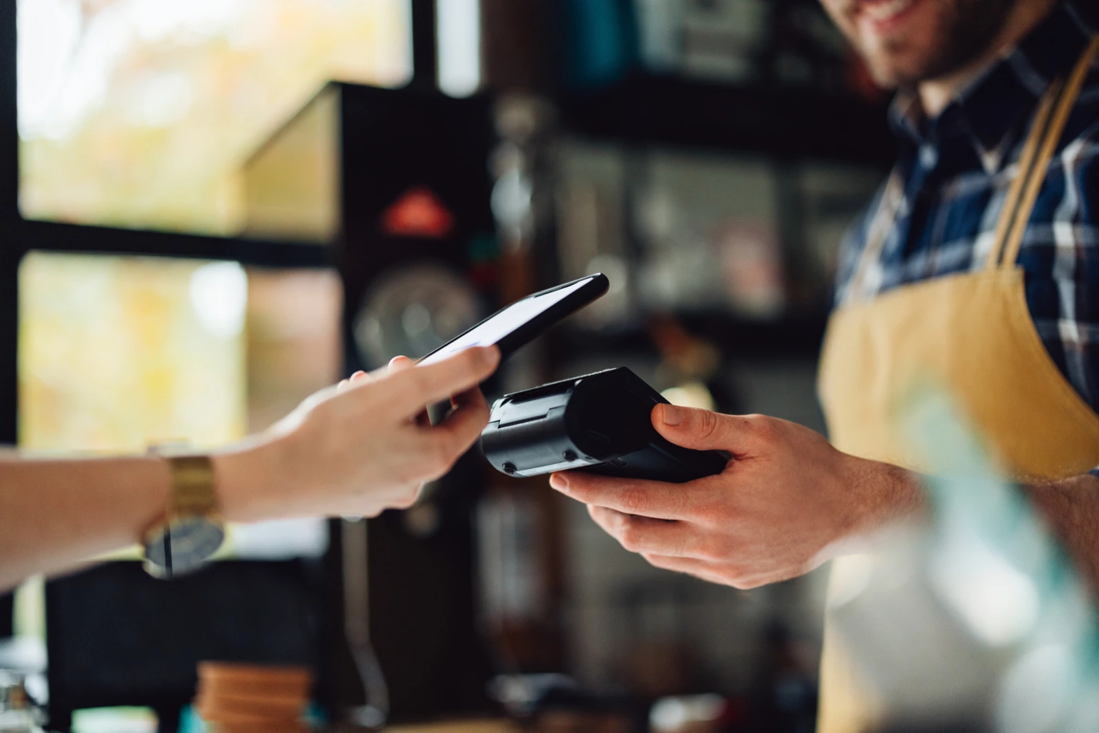 Kontaktlos mit Smartphone in einem Coffee-Shop bezahlen