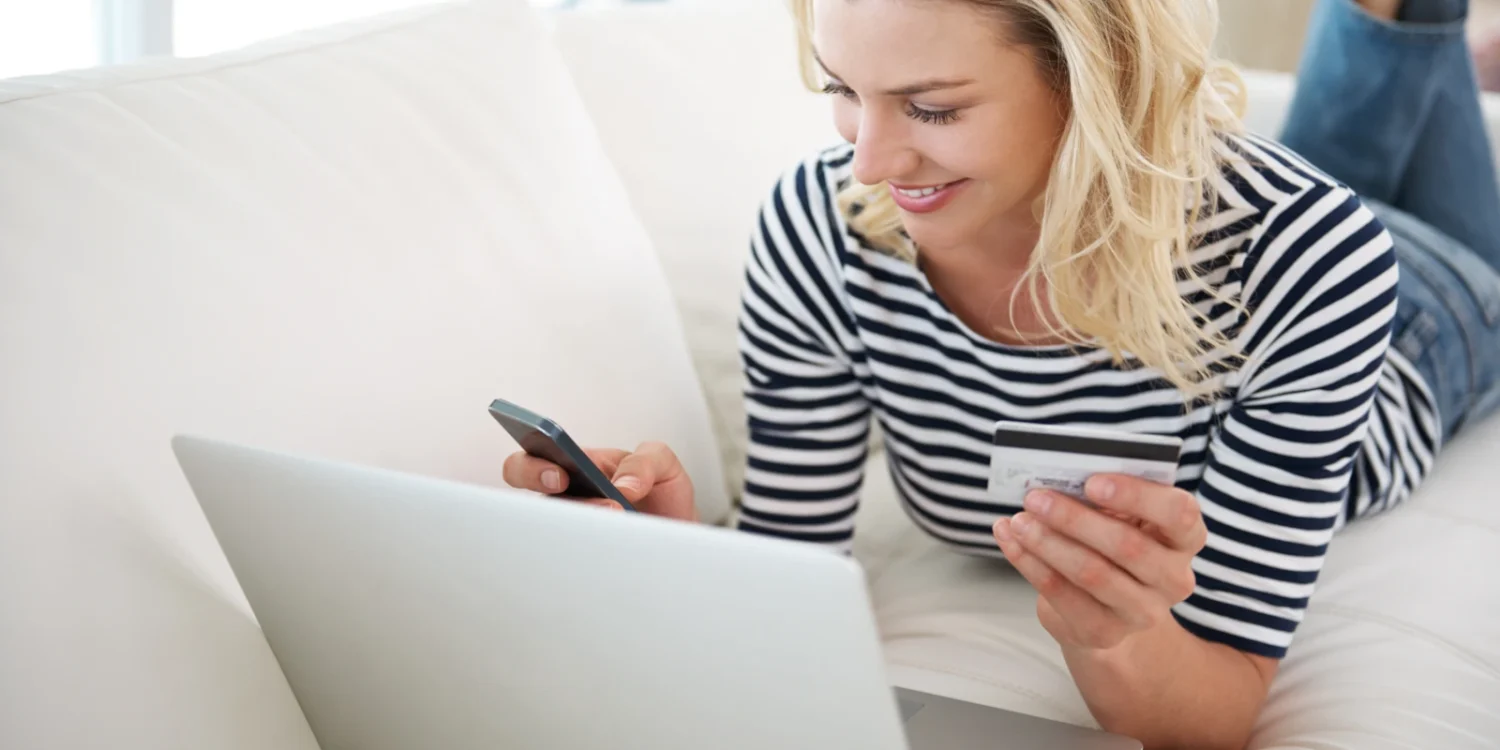 junge Frau mit Kreditkarte und Smartphone beim Online-Shopping