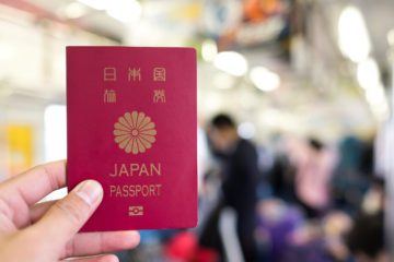 Japanischer Reisepass im Fokus mit Reisenden im Hintergrund