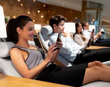 junge selbstständige Geschäftsfrau wartet entspannt in einer Flughafen-Lounge auf ihren Flug