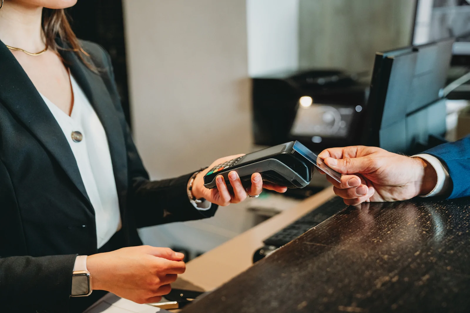 Geschäftsmann bezahlt an der Rezeption eines Hotels mit Kreditkarte