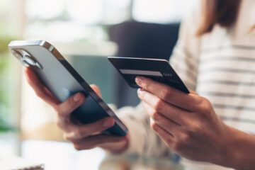 Frau hält eine Kreditkarte in der Hand während des Online-Shopping